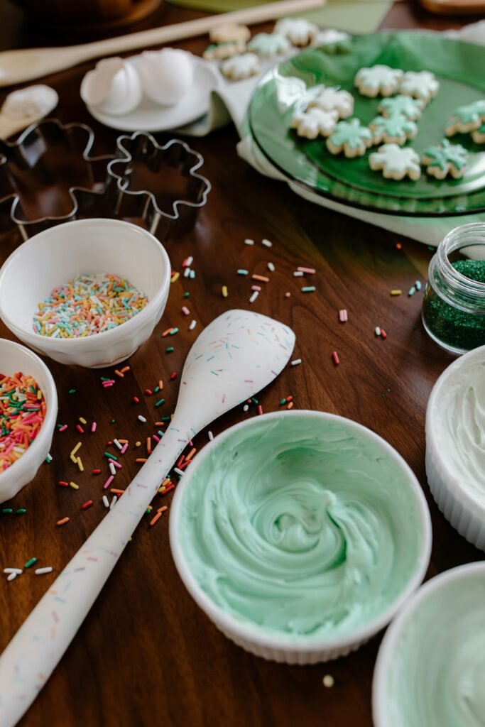 Close-up of St. Patrick's Day baking setup with green icing and sprinkles.