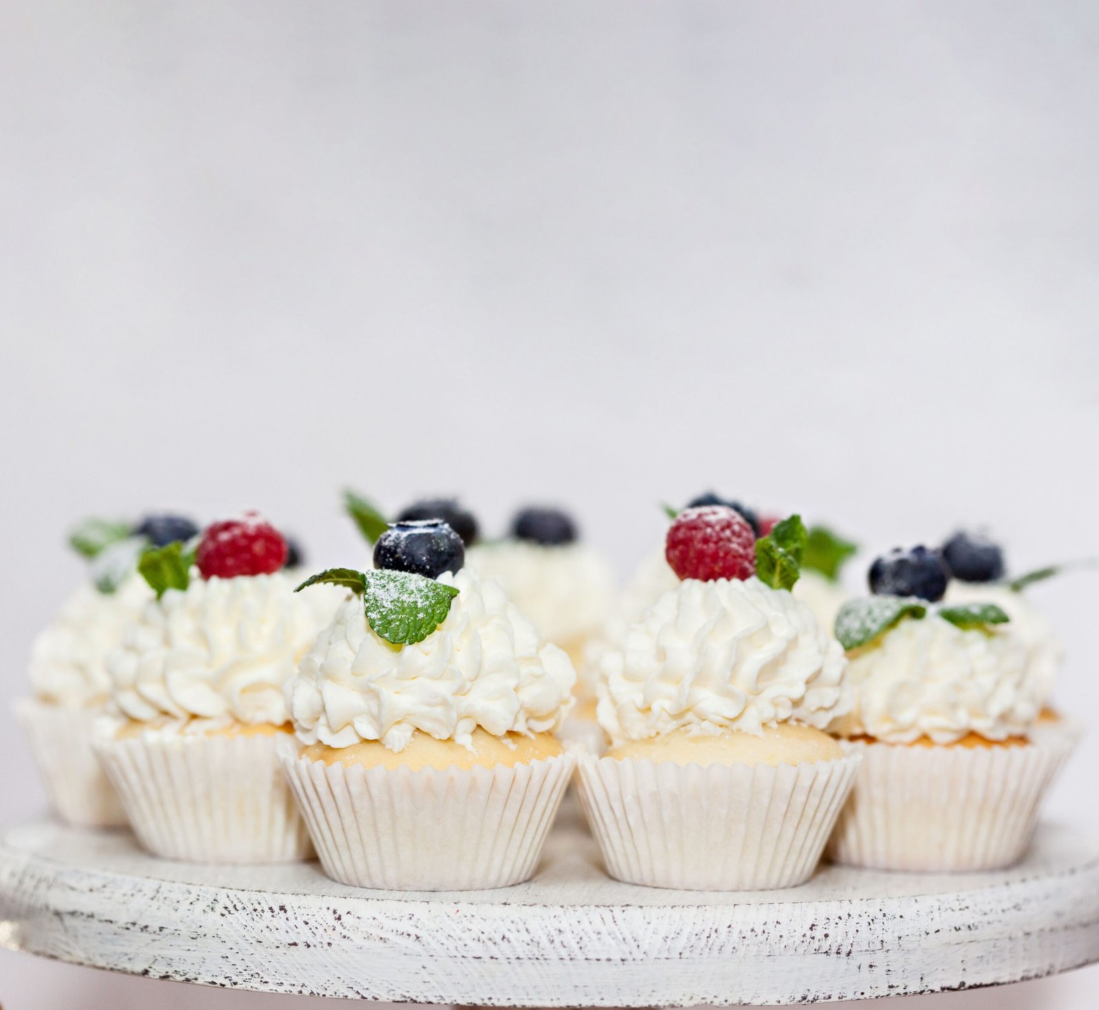 Elegant cupcakes topped with fresh berries and mint. Perfect for dessert lovers.